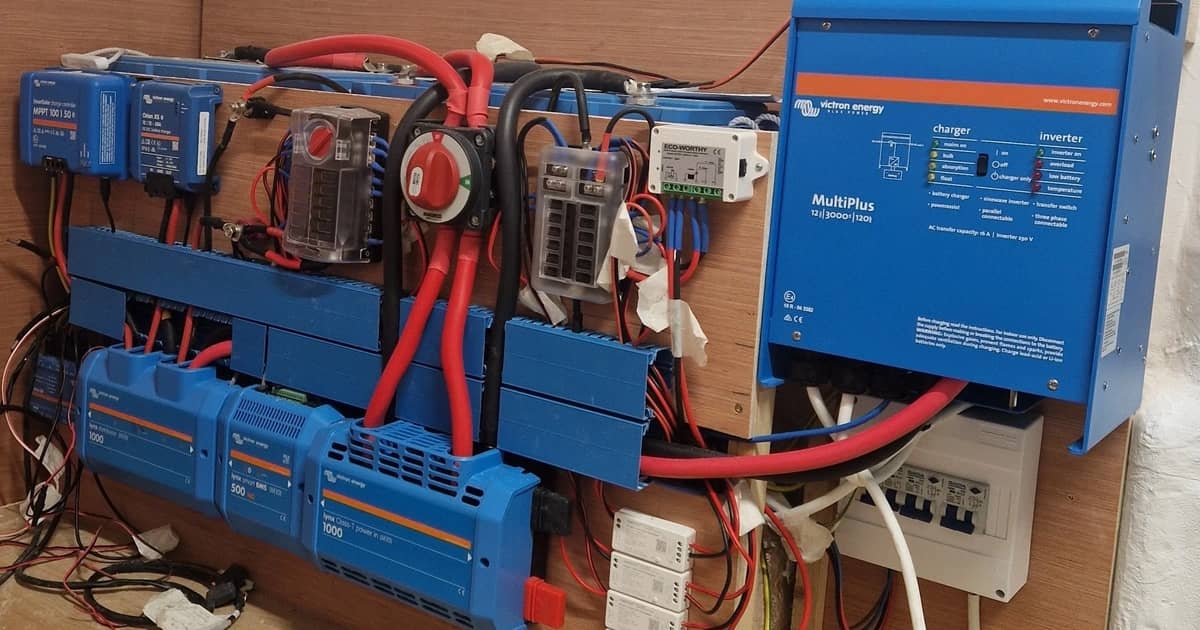Bir karavan duvarına monte edilmiş Victron invertör/şarj cihazı, solar şarj cihazları ve baralar