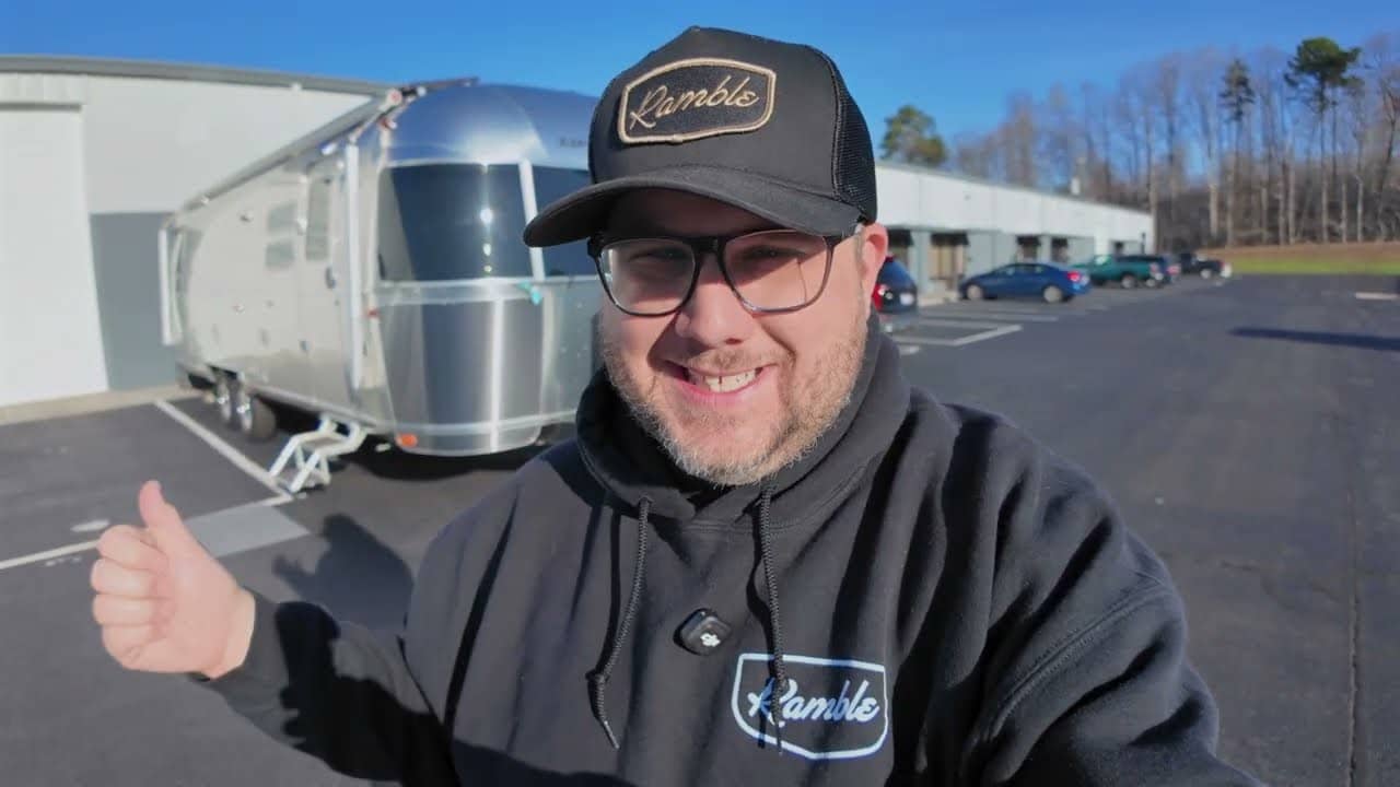 Airstream karavanın önünde duran sunucu — video karesi